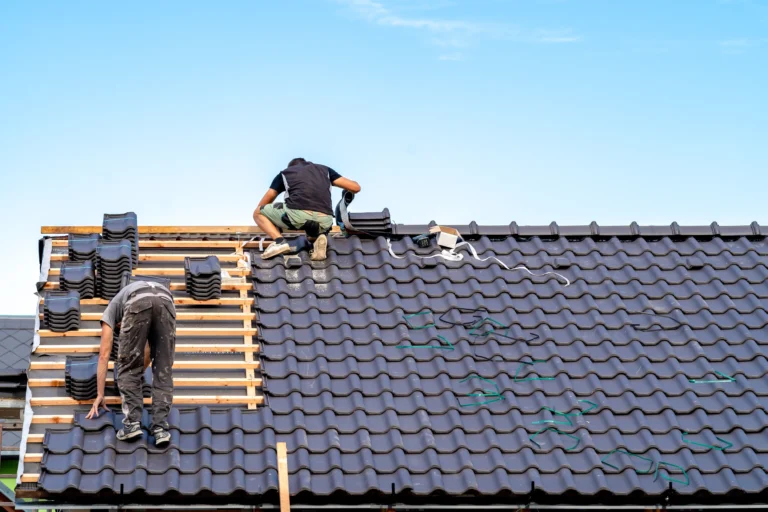 Craftsmen build a new roof from ceramic tiles.